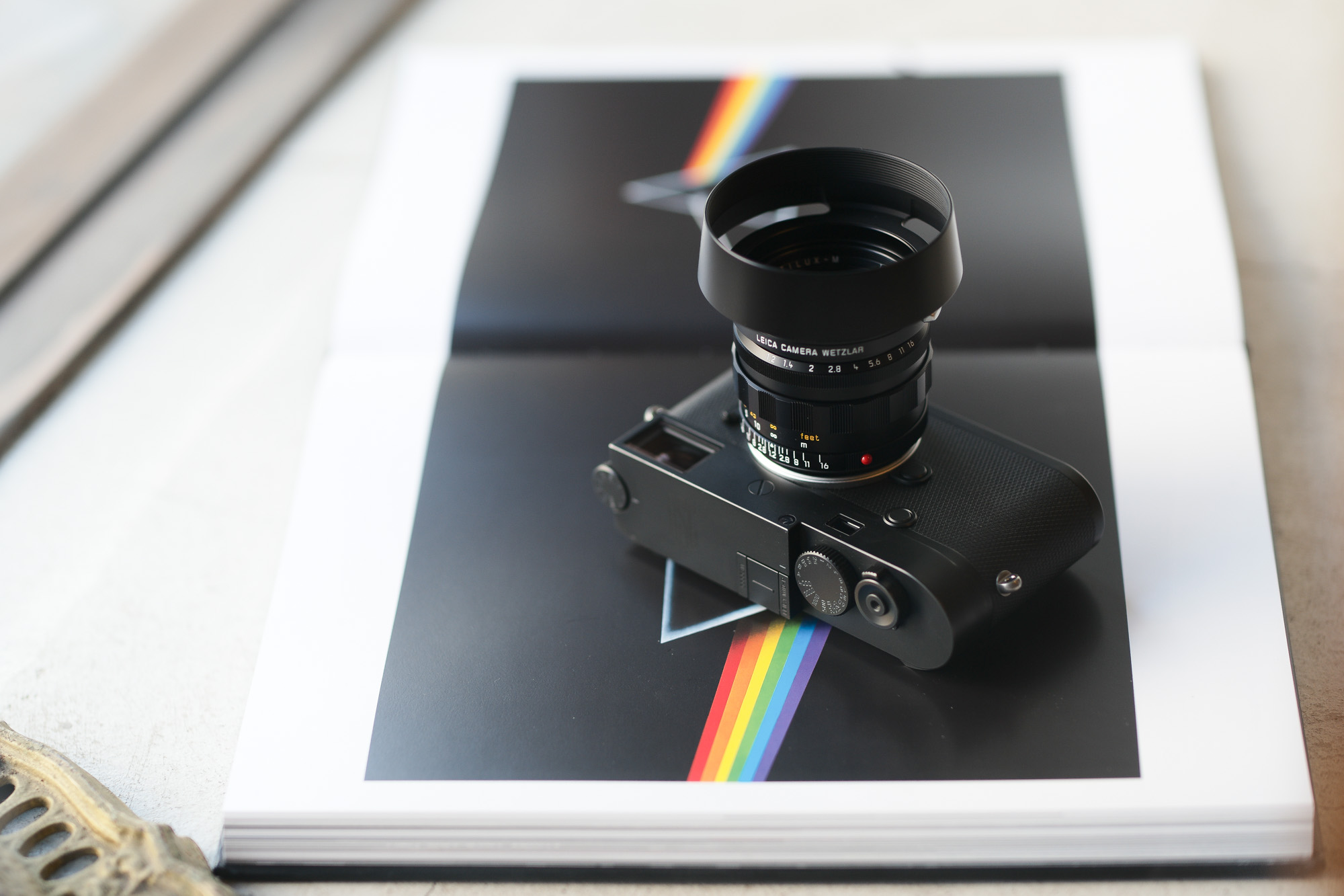 Pink Floyd ピンク・フロイド 2021年2月28日 発売 LEICA NOCTILUX-M 50 f/1.2 ASPH. ライカ ノクティルックス オールドレンズ 銘玉 オールドレンズの魅力に満ちた個性的な描写の銘玉 ライカノクティルックス-M 50 f/1.2 ASPH. ライカMシステムの歴史においても屈指の銘レンズが、最新の理論と技術を駆使して緻密にレンズ設計を行いデジタル時代にふさわしいレンズとして現代に復活しました。オリジナルの「ライカ ノクティルックスM f1.2/50mm」は銘玉として名高く、今なお写真愛好家を魅了してやみません。その理由は、現代の技術においても秀逸な明るい開放値と、精密につくり上げられた非球面レンズ、そして絞り開放時の個性的で美しい描写が得られる優れた性能にあります。このレンズは1966年から1975年にかけてわずか1,757本だけしか製造されなかったため、非常に希少なレンズなのです。闇夜に輝く街灯、車のテールランプ、キャンドルの灯りに照らされる子供の顔、スポットライトを浴びるパフォーマー。ノクティルックスで撮影した写真は、ありのままの自然な印象ではっきりと描き出され、その独特なボケ味によってまるで印象派の絵画のような美しさが漂います。世界中の写真家たちは優れた描写性能を誇るこのレンズを操り、創造力とビジュアルセンスを自由に発揮しながら光と闇が織りなすストーリーを紡ぎ出しています。「新たに登場するライカ ノクティルックスM f1.2/50mm ASPH.は、世界で初めて光学系に非球面レンズを採用したレンズの復刻版です」1966年、ある博覧会で展示された1本のレンズが、きわめて革新的な光学設計で来場者や報道関係者を驚かせました。そのレンズこそが、オリジナル版の「ノクティルックスM f1.2/50mm」でした。当時の基準では圧倒的ともいえる明るさと、非常に優れた光学性能が大きな特長でしたが、その明るさと光学性能が実現できた理由のひとつには、非球面レンズを2枚採用したことが挙げられます。実はこのオリジナル版の「ノクティルックスM f1.2/50mm」は、世界で初めて非球面レンズを採用して一般販売されたレンズです。非球面レンズを採用した目的は、絞り開放で発生する球面収差を低減すること、そして描写力を向上させることでした。今回、歴史に名を刻むこの銘玉を復活させるにあたり、オリジナルの光学設計を可能な限り維持しながら、現代のガラス材料と製造工程に合わせて光学系をつくり上げました。