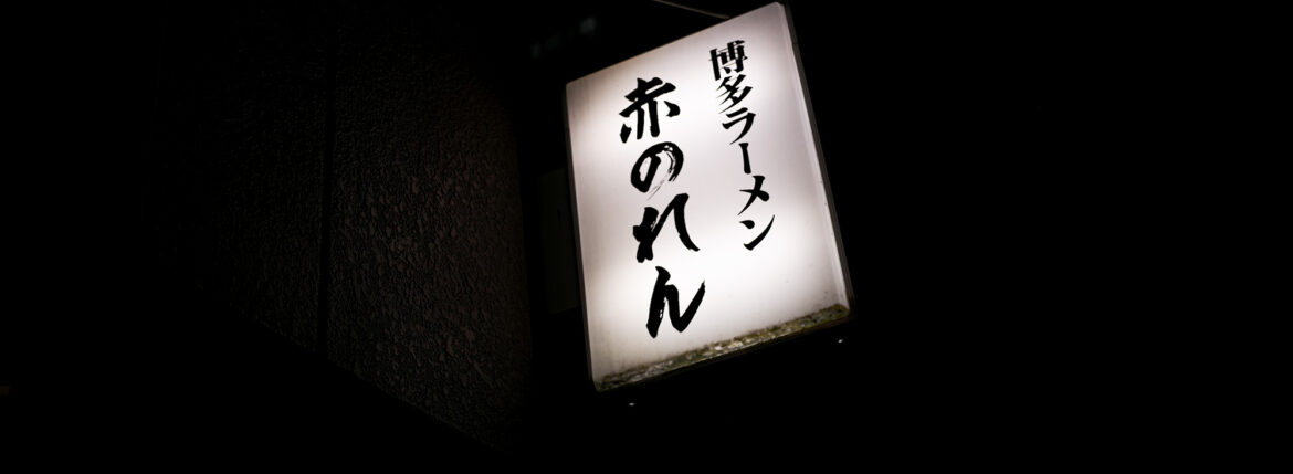 博多麺房 赤のれん 西麻布本店 タモリ 赤のれん タモリ 西麻布交差点 釜炊きとんこつ 東京都 港区 西麻布 3-21-24 第五中岡ビル１Ｆ 釜炊きとんこつ「とれたての味」 「濃厚な豚骨のコクと旨み」と「醤油ダレのキレ」店内に大型の五右衛門釜を持ち込み、毎日一日かけて取るスープはコクと旨みがあって「コッテリ」ながらも、醤油ダレをきかせることにより後味が「サッパリ」になるように仕上げております。厳選した豚骨の部位だけを使用し、丁寧に下処理を行い濃厚な旨みだけを抽出。100％純豚骨スープをお楽しみください。「平打ち極細麺」初代、津田茂氏が考案した極細平打ち極細麺。一般的な麺の断面が丸や角に比べて薄く平べったくなっており、サクッとした食感とスープとの絡みが良いのが特徴です。麺の硬さは、粉おとし・ハリガネ・バリカタ・固め・普通・ヤオ麺の6種類があり、硬さによって食感、小麦粉の風味など大きく変化します。替え玉などで食べ比べるのも楽しいかと思います。本物のラーメンを召し上がりませんか？毎日一日かけて五右衛門釜でとるとんこつスープはコクと旨みがあって後味さっぱり。秘伝の醤油ダレを加えたスープが極細平打麺にからむ絶妙の味です。釜炊きとんこつ「とれたての味」をご賞味ください。「由来」福岡は箱崎で津田茂氏が開業した博多ラーメン赤のれんは「腰が強い平打ち細麺］と「こってり味でさっぱり感のある醤油仕立てのとんこつラーメン」が造りだす絶品の旨さが大人気となり、昭和50年頃はその味は博多随一と評判でした。この地に赤のれんが誕生した由来は、博多赤のれんに弟子入りした先代が六本木付近に創業の場所を求めたことにあります。六本木から西麻布にかけてこのとおり一帯は、昔から「元すりとおり」と呼ばれ地元の人たちから商売は難しい場所と見られていました。西麻布に創業し40年、ひたすらに本物の味を追及しお客様の求める旨い味づくりに専念してまいりました。今も変わらず商いができますのもお客様の暖かい支持の賜物と感謝いたしております。 https://www.akanoren.com/
