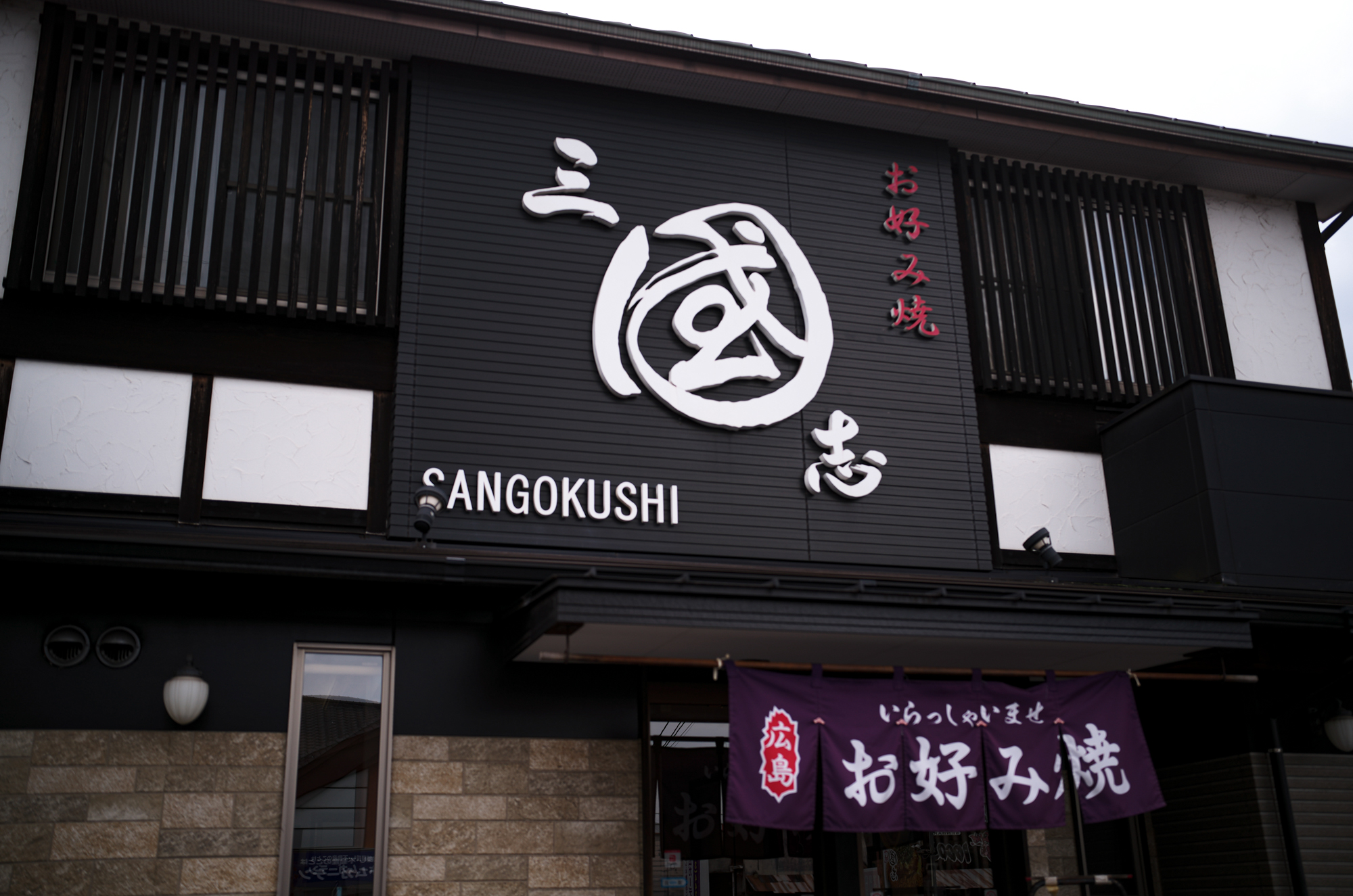 三國志　〒721-0907 広島県福山市春日町６丁目９−１０ oko_sangoku  広島名物お好み焼き、鉄板焼き  広島名物 広島風お好み焼き、多くの種類のトッピングの組み合わせで、 オリジナルお好み焼きをお楽しみ下さい。広島県 福山市 福山東インターチェンジから 車で約１０分 広島 お好み焼の お店。キャベツたっぷり　生麺使用　数種のスパイスが隠し味　鉄板で熱々のお好み焼を是非！　冷凍お好み焼販売中　ご家庭にストック　いつでも美味しい。「お好み焼・鉄板焼　三國志」（福山市春日町6-9-10、藤井啓文代表）はこのほど、冷凍お好み焼きを開発して販売を始めた。 　コロナ禍で店内での飲食が減る中、スーパーやコンビニでは冷凍食品の需要が増えていることから、お好み焼きの冷凍販売を思いついたという。「二四時間、出来たての味を楽しんでほしい」と昨年から開発に乗り出した。「レンジで温めた際、店内で食べるお好み焼きと同じ状態になるよう工夫した」と藤井代表。店内で提供する物と同じ材料で焼き上げ、専用の機械で急速冷凍する。レンジでの加熱を考慮し、焼く時間を通常の七─八割に抑えて調整を重ねたという。 　肉玉（760円）、イカ・エビ・肉玉入りの「三國志スペシャル」（1040円）をはじめ、イカ天肉玉（880円）、チーズ肉玉（860円）など約10種類がある。 　レンジで温める時間は七分前後。肉玉の場合は裏返して三分、表にして四分温める。最後に別袋入りのソースをかければ完成。同店ならではの、飽きのこないやさしい味が楽しめる。常連客からは「店で食べるのと同じくらいおいしかった 「冷凍庫にストックしておいて、食べたい時に食べられるのがうれしい」といった声が寄せられているとか。藤井代表は「自宅用やお土産にぜひどうぞ。準備が整えば、地方発送も始めます」と話す。 　なお、夏をめどに価格の改定を行う予定。また一度に10枚以上購入する場合は、一週間前までに予約が必要。 　ホルモン焼き（860円）や焼きそば（710円）など鉄板焼きメニューの冷凍商品も用意している。